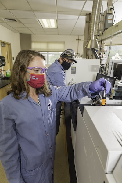 Masked chemistry students study lab equipment