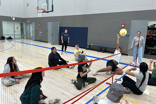 Students playing volleyball sitting down Students playing volleyball sitting down